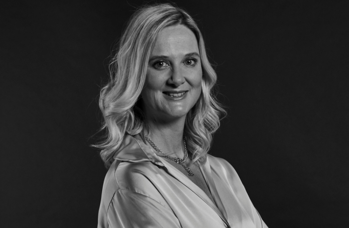 Kate Nixon headshot Black and white headshot of Kate Nixon on a black background